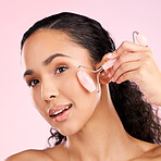 Face roller, natural beauty and woman with skin glow, health or wellness cosmetics. Headshot of a young aesthetic female model with dermatology and facial massage results on a pink background
