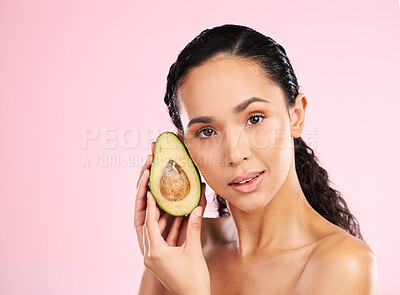 Buy stock photo Face, skincare and serious woman with avocado in studio isolated on pink background mockup space. Portrait, natural cosmetic and model with fruit, food or nutrition for diet, vegan health or omega 3