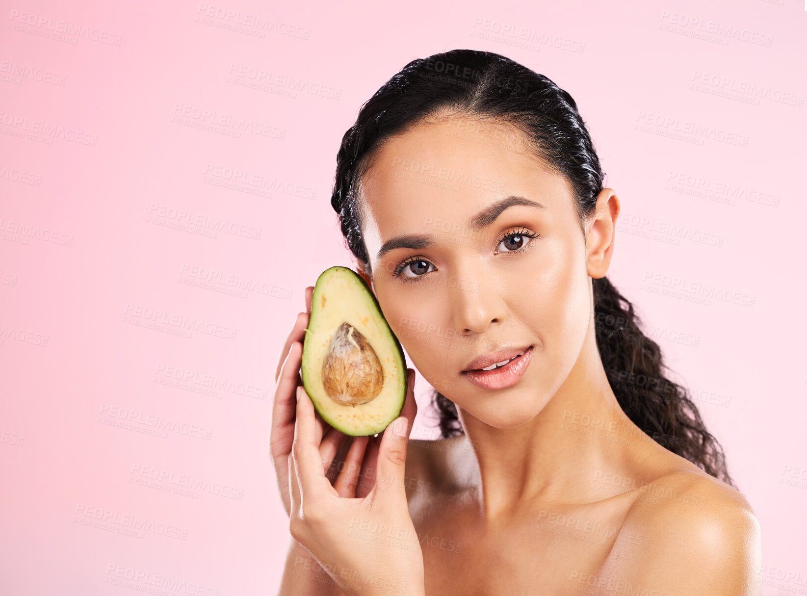 Buy stock photo Face, skincare and serious woman with avocado in studio isolated on pink background mockup space. Portrait, natural cosmetic and model with fruit, food or nutrition for diet, vegan health or omega 3