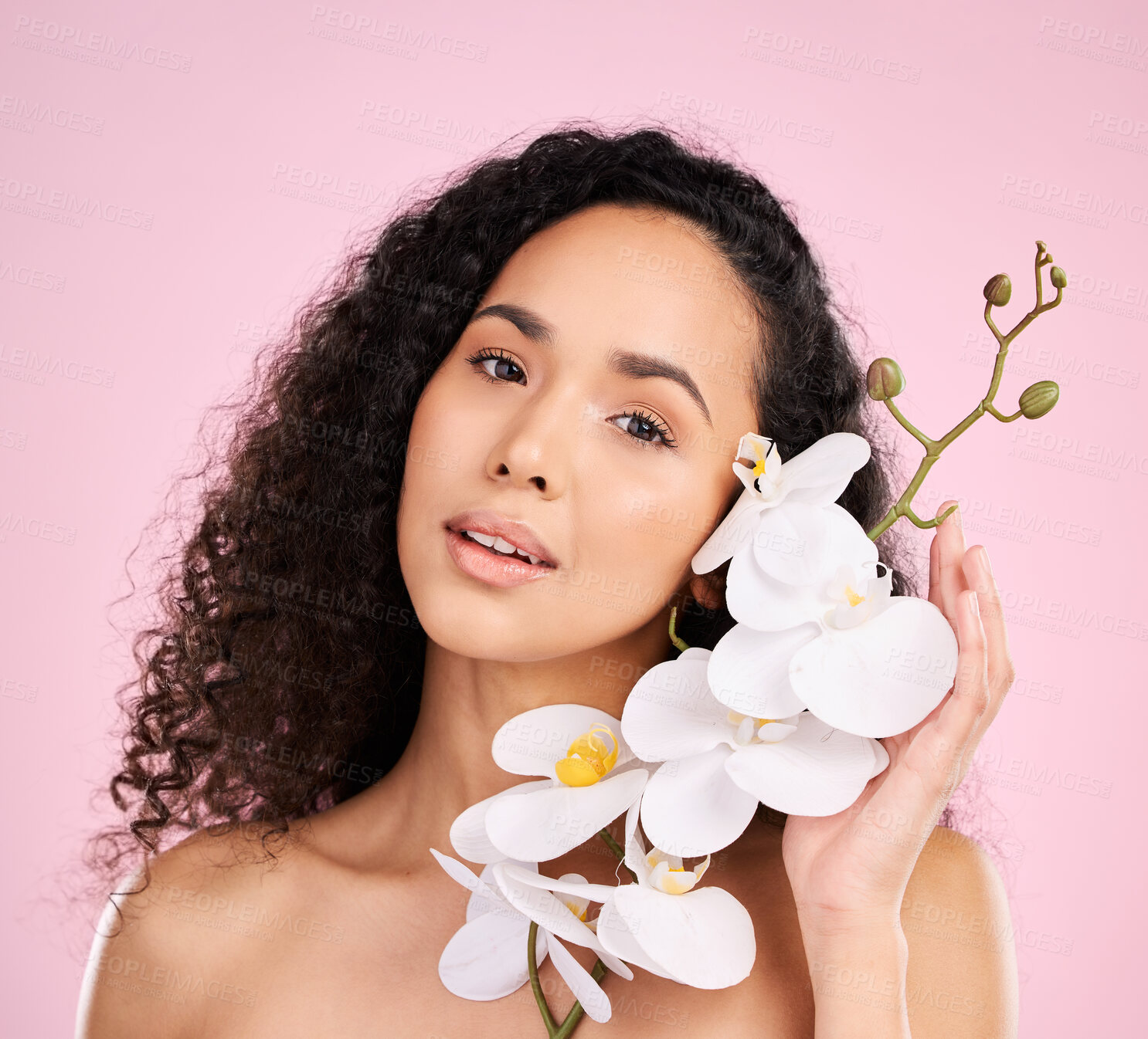 Buy stock photo Face, orchid and skincare of woman for beauty in studio isolated on a pink background. Portrait, flowers and model with plant, floral cosmetic or natural organic treatment for healthy skin aesthetic