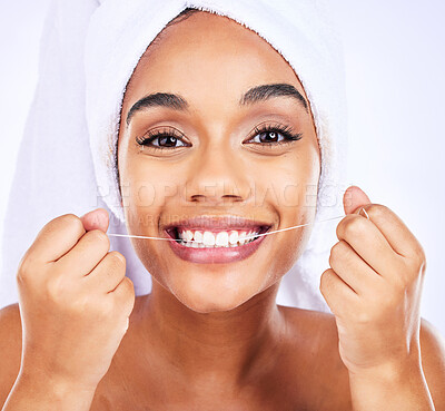 Buy stock photo Dental floss, teeth and face of a woman for health and wellness in studio. Portrait of a young female model flossing, cleaning and self care for fresh breath, hygiene and shine on a white background