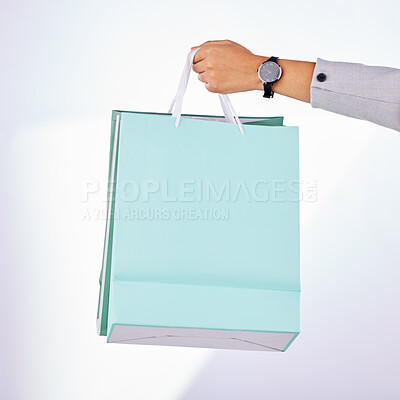 Buy stock photo Hands, person and bag of shopping in studio, white background or fashion deal in retail product. Closeup of rich customer giving gift bags, luxury present and discount sales purchase on store credit