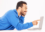 Smile, laptop and man pointing on studio floor isolated on a white background. Computer, happy or person on ground for social media, streaming movie or film, video or show on internet with technology