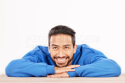 Buy stock photo Thinking, wonder and face of man on a white background with ideas, brainstorming and dream by table. Happy, mockup space and isolated male person resting on desk for choice or decision in studio