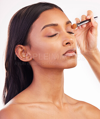 Buy stock photo Beauty, makeup and brush on face of woman in studio for cosmetics, foundation and eyeshadow. Salon, self care and glow with female model on white background for application, powder and facial 