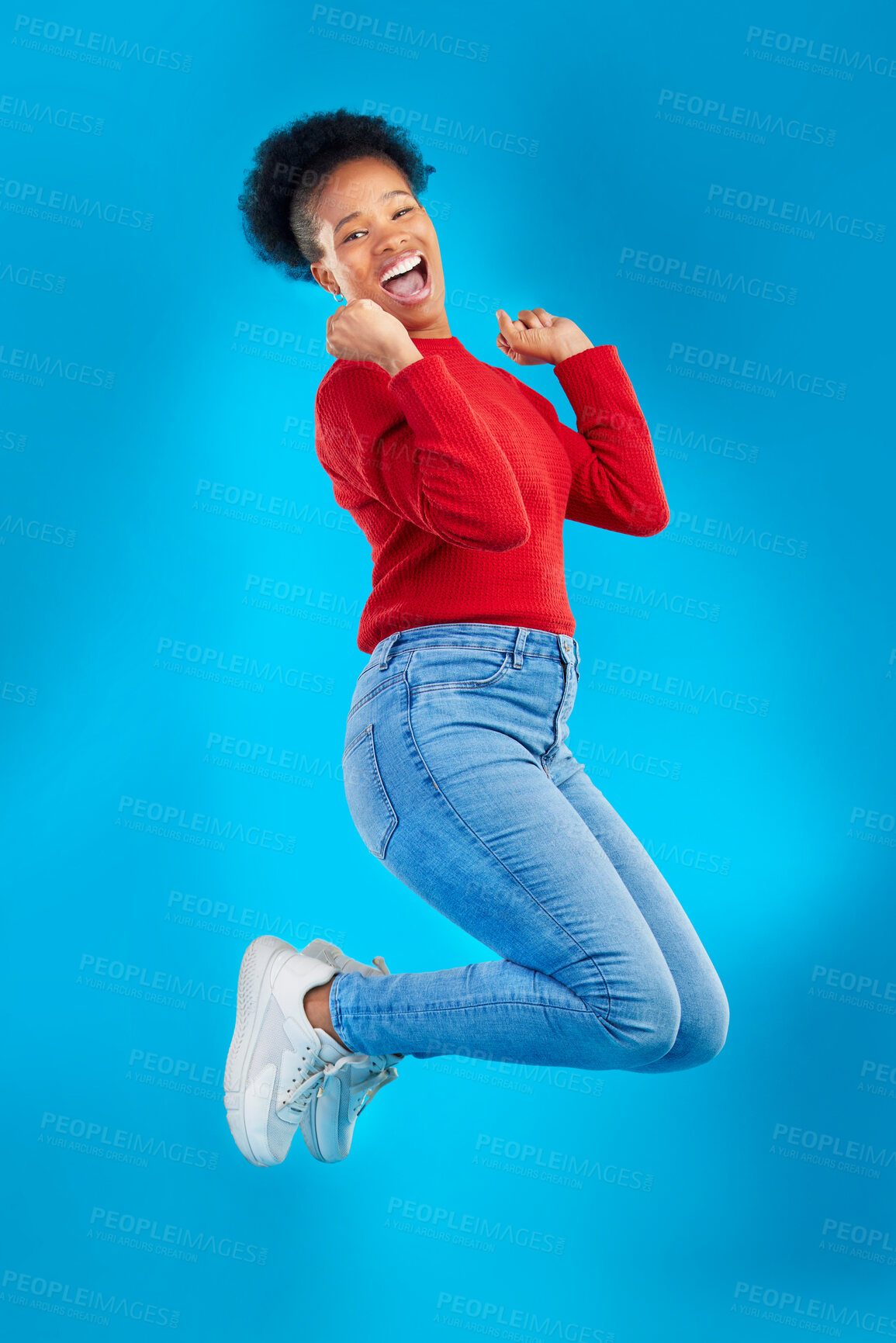 Buy stock photo Excited, jump and woman portrait with winner, deal and smile in a studio. Wow, energy and up in the air with female person and blue background with celebration for sale announcement and big news