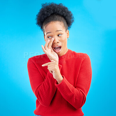 Buy stock photo Secret, gossip and black woman in studio pointing isolated on a blue background. Happy, whisper and African person with deal, promotion or news for offer, privacy and announcement of info on mockup