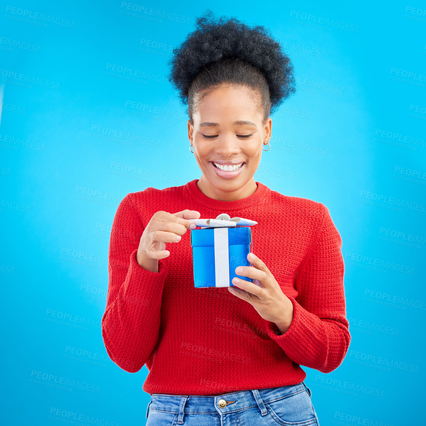 Buy stock photo Smile, birthday and a black woman with a gift on a blue background for happiness or a surprise. Holding, box and a young African girl with a present for a celebration isolated on a studio backdrop