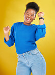 Happy, dance and young woman in studio for celebration, achievement or goal with confidence. Happiness, smile and African female model moving to music, song or playlist isolated by yellow background.