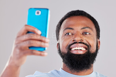 Buy stock photo Happy black man, face and selfie in photography for social media, vlog or networking against a grey studio background. African male person smile for photo, memory or online communication and picture