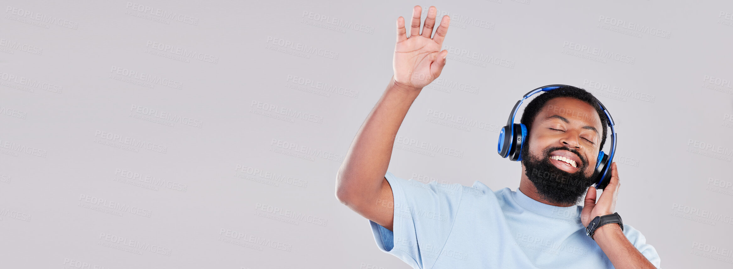 Buy stock photo Headphones, mockup and young man in a studio listening to music, playlist or album while dancing. Happy, smile and African male model streaming a song or radio by a gray background with mock up space