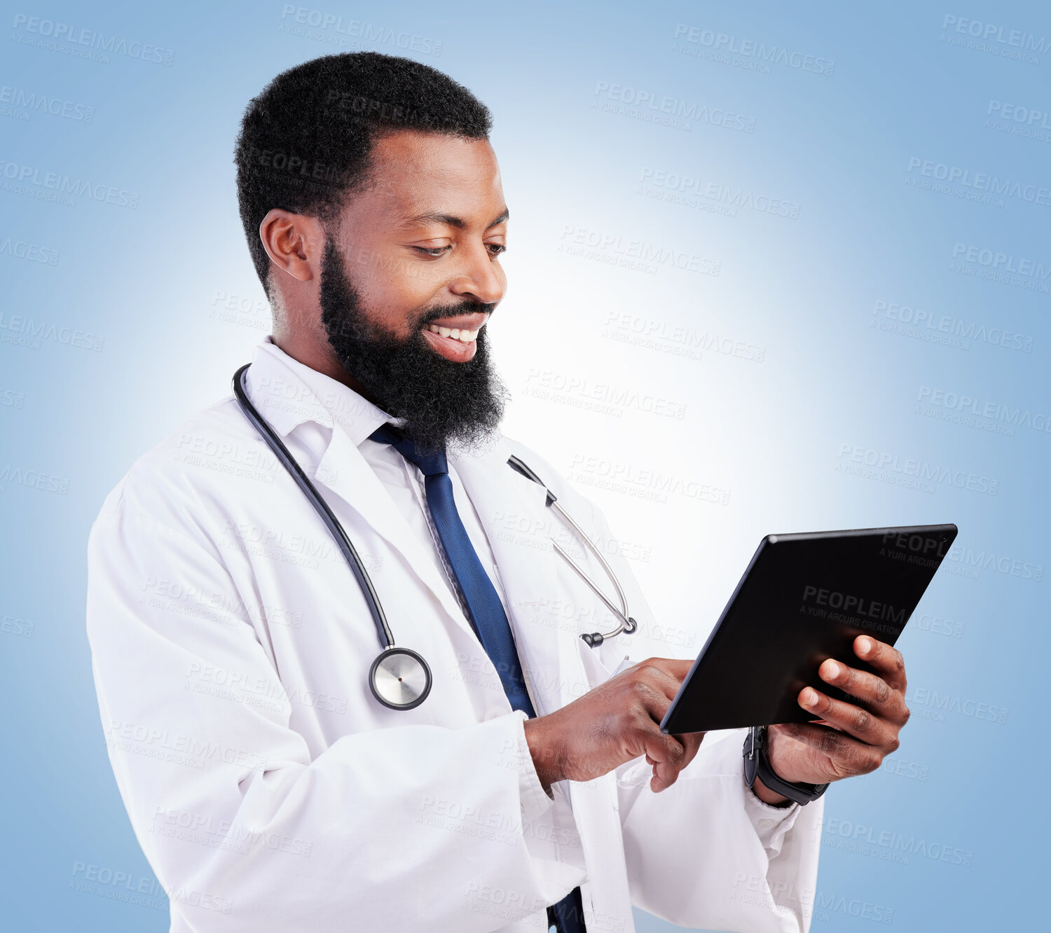 Buy stock photo Healthcare, tablet and a black man doctor on a blue background in studio for cardiology research. Medical, technology and innovation with a male medicine professional reading information online