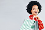 Shopping bag, portrait and young woman for fashion discount, sale and retail promotion on a white background. Gift, giveaway and happy customer, model or african person with mockup space in studio