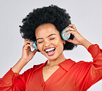 Excited black woman, music and headphones in studio for podcast subscription on white background. Face of happy female model singing while listening to audio, streaming sound or hearing song on radio