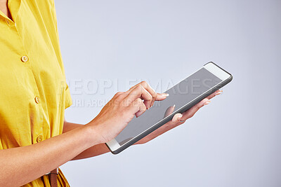 Buy stock photo Hands, tablet and closeup of a woman in studio scrolling on social media, mobile app or the internet. Online, research and female person browsing on website with digital technology by gray background