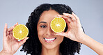 Portrait, skincare and woman with lemon eye for wellness or nutrition in grey studio background. Happy face, girl and  vitamin c for dermatology with smile, fruit, diet or natural facial treatment.