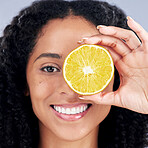 Portrait, wellness and woman with lemon eye for nutrition in closeup in grey studio background. Skincare, girl and vitamin c  for facial treatment with natural organic food for dermatology or fruit.