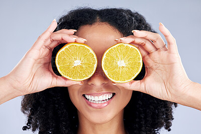 Buy stock photo Woman, lemon eyes and skincare in studio for comic smile, health or nutrition for wellness by background. Girl, African model and fruits for diet, cleaning and cosmetic for beauty, self care or emoji