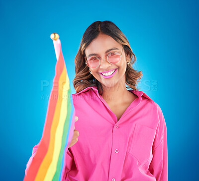 Buy stock photo Woman, lgbtq and rainbow flag in studio portrait, sunglasses and icon for pride with human rights by blue background. Gen z girl, lesbian student and wave sign for solidarity, freedom and inclusion