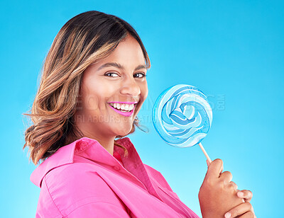 Buy stock photo Woman, lollipop and smile in studio portrait with eating, sweets and excited for food by blue background. Girl, student or young fashion model with candy, beauty or happy with sugar for dessert snack