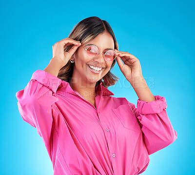 Buy stock photo Fashion sunglasses, portrait and happy woman in studio isolated on a blue background. Face, glasses and Indian model with style, designer shades and positive mindset for aesthetic, gen z and smile