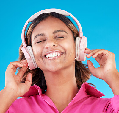 Buy stock photo Headphones, happy music and woman or student with streaming service with mental health podcast in studio. Young african person listening to radio, electronics and audio technology on blue background