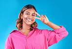 Smile, happy and peace sign with portrait of woman in studio for support, gen z and emoji. Motivation, kindness and winner with face of person on blue background for v icon, positive and symbol