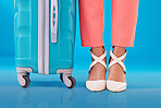 Closeup, woman and shoes with suitcase, standing and fashion on a blue studio background. Zoom, person and model with luggage, stylish footwear and baggage for travel with human and business trip 