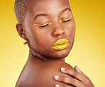 Creative, makeup and woman in a studio with cosmetic eyeliner and lipstick for cosmetology. Self care, glamour and young African female model with a colorful face routine by a yellow background.