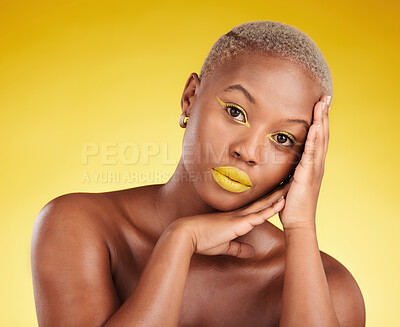 Buy stock photo Cosmetics, glow and african girl in portrait for skincare in yellow studio or gold background for facial. Woman, serious and hand on face with makeup for spa treatment for dermatology or wellness.