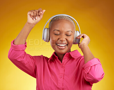 Buy stock photo Music headphones, smile and black woman dancing in studio isolated on a yellow background. African person, happy and listening to radio, jazz or streaming audio, podcast and hearing sound with energy
