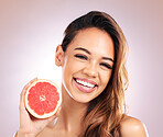 Happy woman, portrait smile and grapefruit for vitamin C skincare against a studio background. Face of female person with organic fruit for natural nutrition, diet or healthy wellness in happiness
