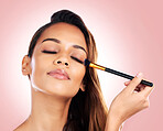 Makeup, eyeshadow and face of woman with brush on pink background for beauty, wellness and luxury. Cosmetology, aesthetic and female person with tools for foundation, cosmetics and glamour in studio