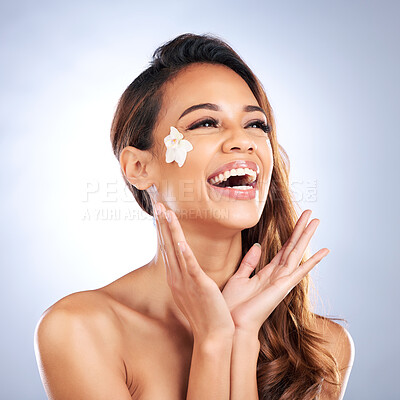 Buy stock photo Beauty, smile and woman with flower on face, natural makeup and spa treatment on white background. Dermatology, skincare and nature, happy model with petals and organic facial cosmetics in studio.
