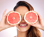 Beauty, grapefruit and eyes of woman with healthy, natural or organic care isolated in a brown studio background. Citrus, happy and young female person with vitamin c for skincare, wellness or detox