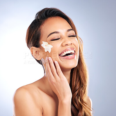 Buy stock photo Beauty, cosmetics and happy woman with flower on face, natural makeup and spa treatment on white background. Dermatology, skincare glow and model with floral cream for organic facial care in studio.