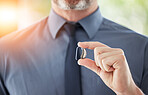 Hearing aid, hands and business man with disability for communication support, listening and medical innovation. Closeup of deaf worker with audiology implant to help sound waves, amplifier or volume