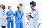 Healthcare, doctor and a black woman with a tablet at a hospital for communication and online service. Wellness, research and an African nurse or surgeon typing on technology at a clinic for medicine