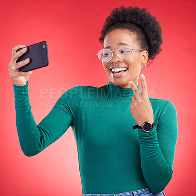 Buy stock photo Happy black woman, peace sign and selfie for photography against a red studio background. African female person or model smile for photograph, memory or social media and online post in happiness