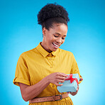 Happy, gift and a black woman in studio with a surprise for birthday, celebration or holiday. Fashion, present and african female person on a blue background with a box, ribbon and prize or package