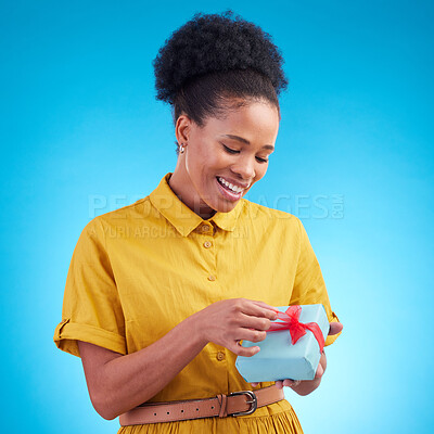 Buy stock photo Happy, gift and a black woman in studio with a surprise for birthday, celebration or holiday. Fashion, present and african female person on a blue background with a box, ribbon and prize or package