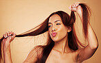 Haircare, beauty and happy woman with hair in hands, luxury salon treatment and brown background space. Aesthetic, haircut and smile, excited model with cosmetics and keratin kiss in studio mockup.