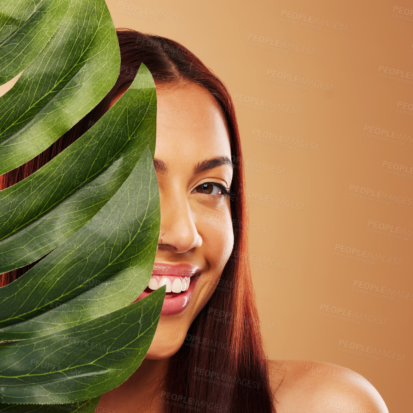 Buy stock photo Leaf, beauty and portrait of a happy woman in studio for natural dermatology, cosmetics or wellness. Skin care, nature and monstera plant for eco friendly facial of model person on brown background 