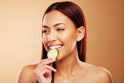 Buy stock photo Thinking, cucumber and woman with skincare, dermatology and cosmetics on a brown studio background. Female person, healthy fruit and model with wellness, glow and beauty with shine, natural and ideas