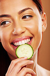 Thinking, cucumber and woman with skincare, natural beauty and cosmetics on a brown studio background. Female person, healthy fruit and model with wellness, glow and dermatology with shine and ideas