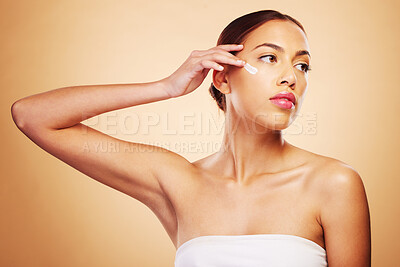 Buy stock photo Skincare, beauty and a woman with cream on a studio background for wellness and moisture. Cosmetics, product and a young girl or model with lotion or sunscreen for facial skin health on a backdrop