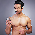 Topless, cosmetics or man with cologne for beauty or self care isolated on studio background. Wellness, male person or Asian model with luxury body perfume spray with fragrance bottle or grooming