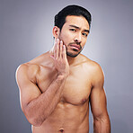 Portrait, skincare and man with beauty, cosmetics and dermatology against a grey studio background. Face, male person and model with grooming routine, muscle and facial with wellness, shine and glow