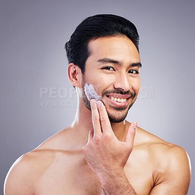 Buy stock photo Cosmetics, skincare or portrait of happy man with face cream or sunscreen product in grooming routine. Dermatology, studio background or confident Asian model smiling or applying facial creme lotion
