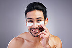 Portrait, skincare or happy man with eye patch for beauty or wellness isolated on studio background. Cosmetics, smile or model with facial collagen pads or dermatology product for anti aging or glow